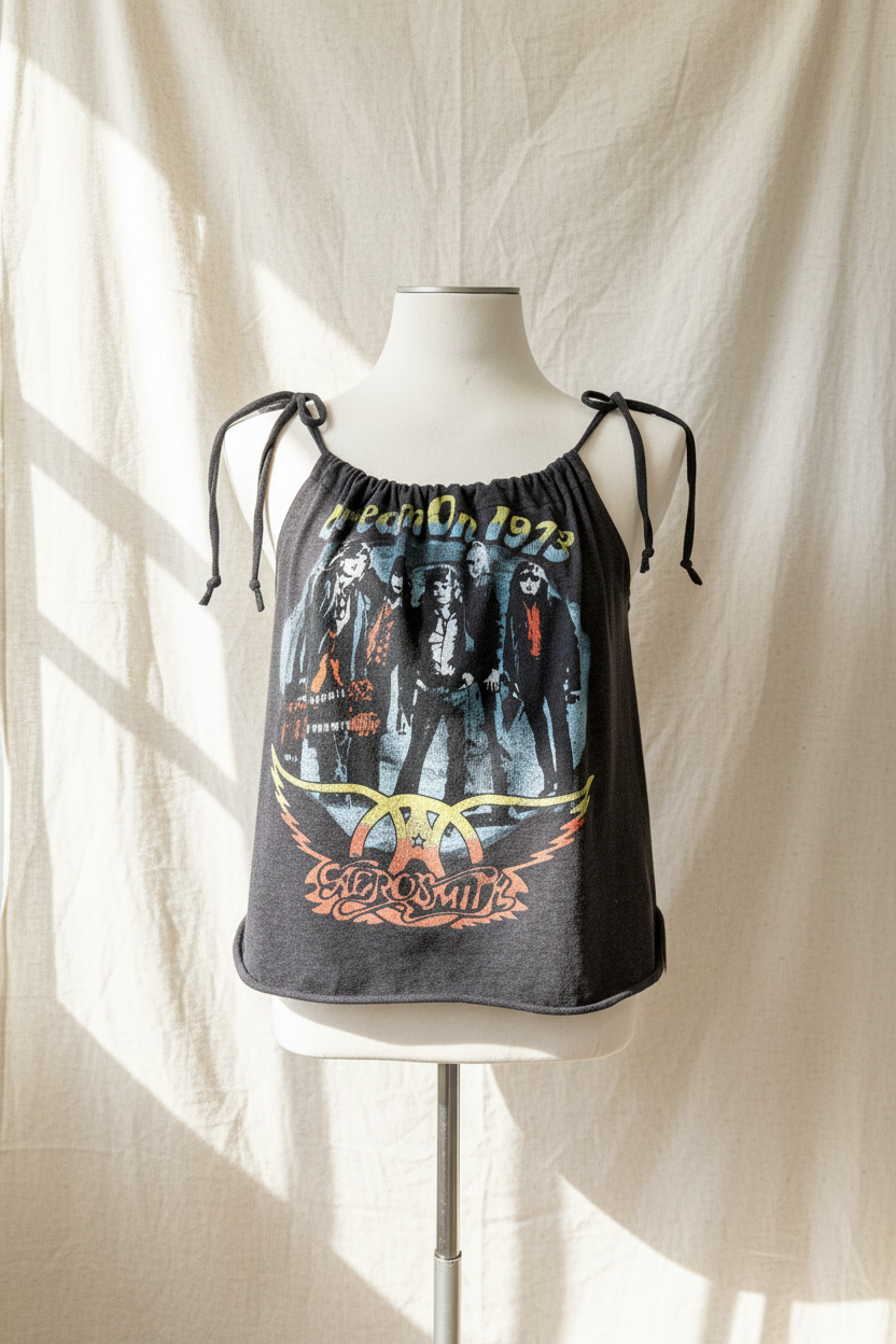 Black tank top with graphic design on a mannequin against a white curtain background
